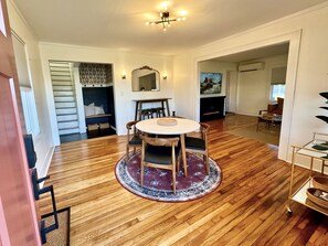 A spacious living area with a round wooden dining table, a fireplace, and a large mirror. - Renovated Gem Near Cantine Field, HITS & Hunter (Saugerties)