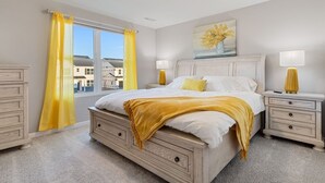 Een slaapkamer met een groot bed, twee nachtkastjes, een raam met gele gordijnen en een schilderij aan de muur.