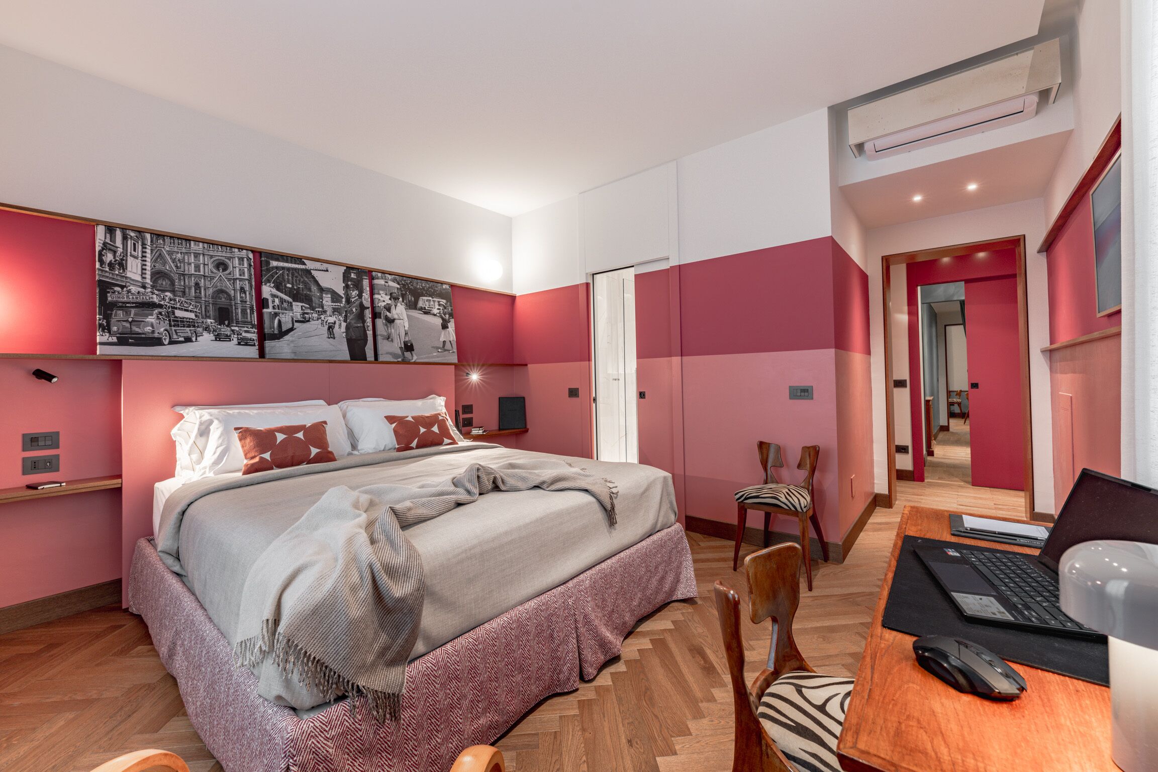 Une chambre moderne avec un lit, un bureau doté d’un ordinateur portable et une chaise.