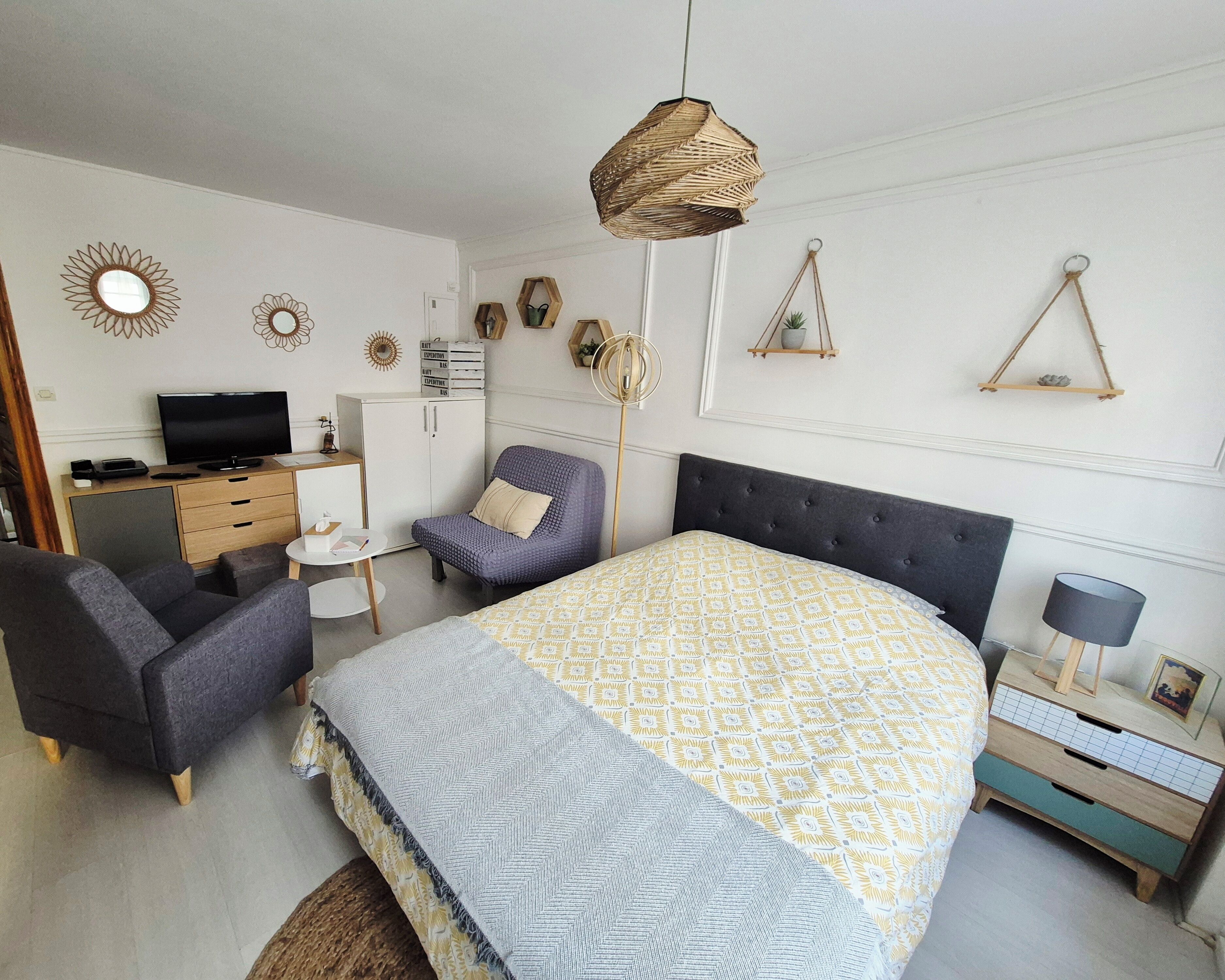 Ein Schlafzimmer mit Bett, Schreibtisch, Stuhl und Fernseher.