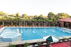 Relax by the pool with a hot tub and comfortable seating area.