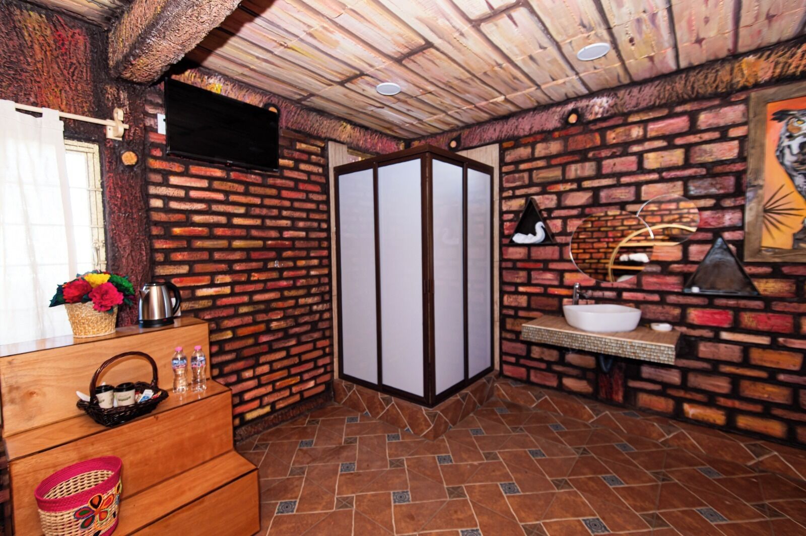 Une salle de bain avec un mur en briques, un meuble-lavabo en bois, un évier, un miroir et un porte-serviettes.