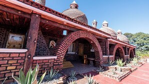Un bâtiment traditionnel de style adobe, avec des murs en briques, des portes en arc de cercle et des toits en forme de dôme.