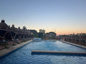 Relax by the serene pool surrounded by elegant brick structures.