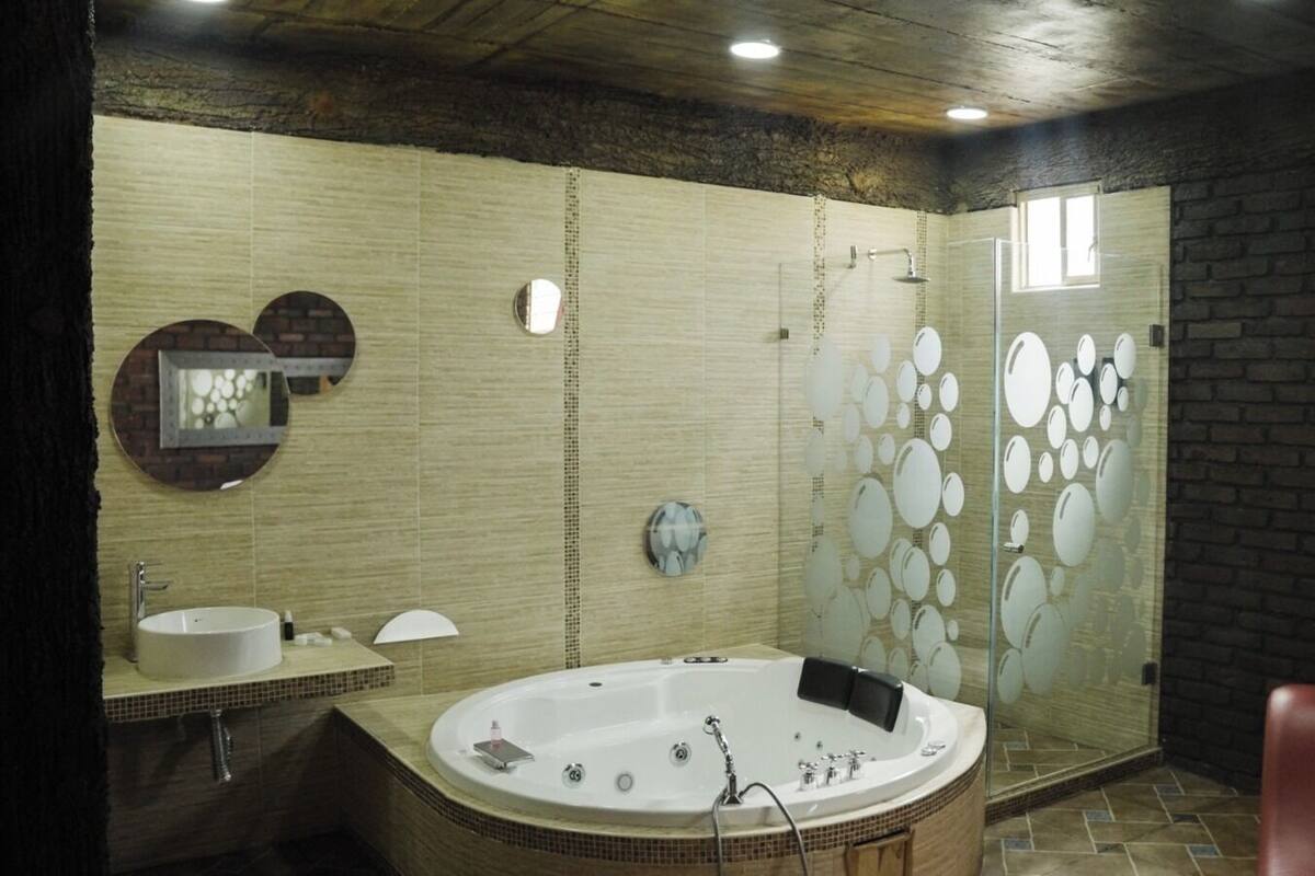 A modern bathroom with a freestanding bathtub, a glass-enclosed shower, and a large mirror.