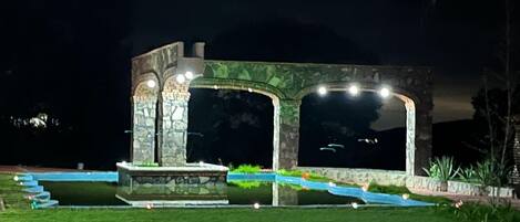 Un edificio de piedra con grandes ventanales arqueados y una fuente en primer plano.