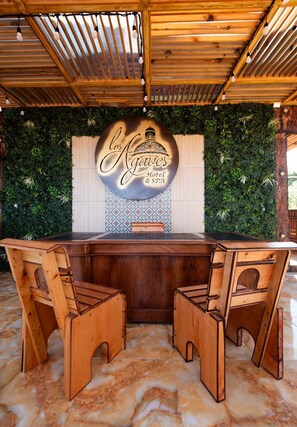 Enjoy a drink at the hotel's central bar, surrounded by a unique green wall and patterned tile design.