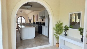 A spacious kitchen with an island, white cabinetry, and a large window. - Feel like when you're at home.
12462311839 (All Regions)