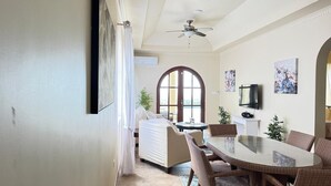 A dining area with a round table, wicker chairs, a ceiling fan, and a large window with a view. - Feel like when you're at home.
12462311839 (All Regions)