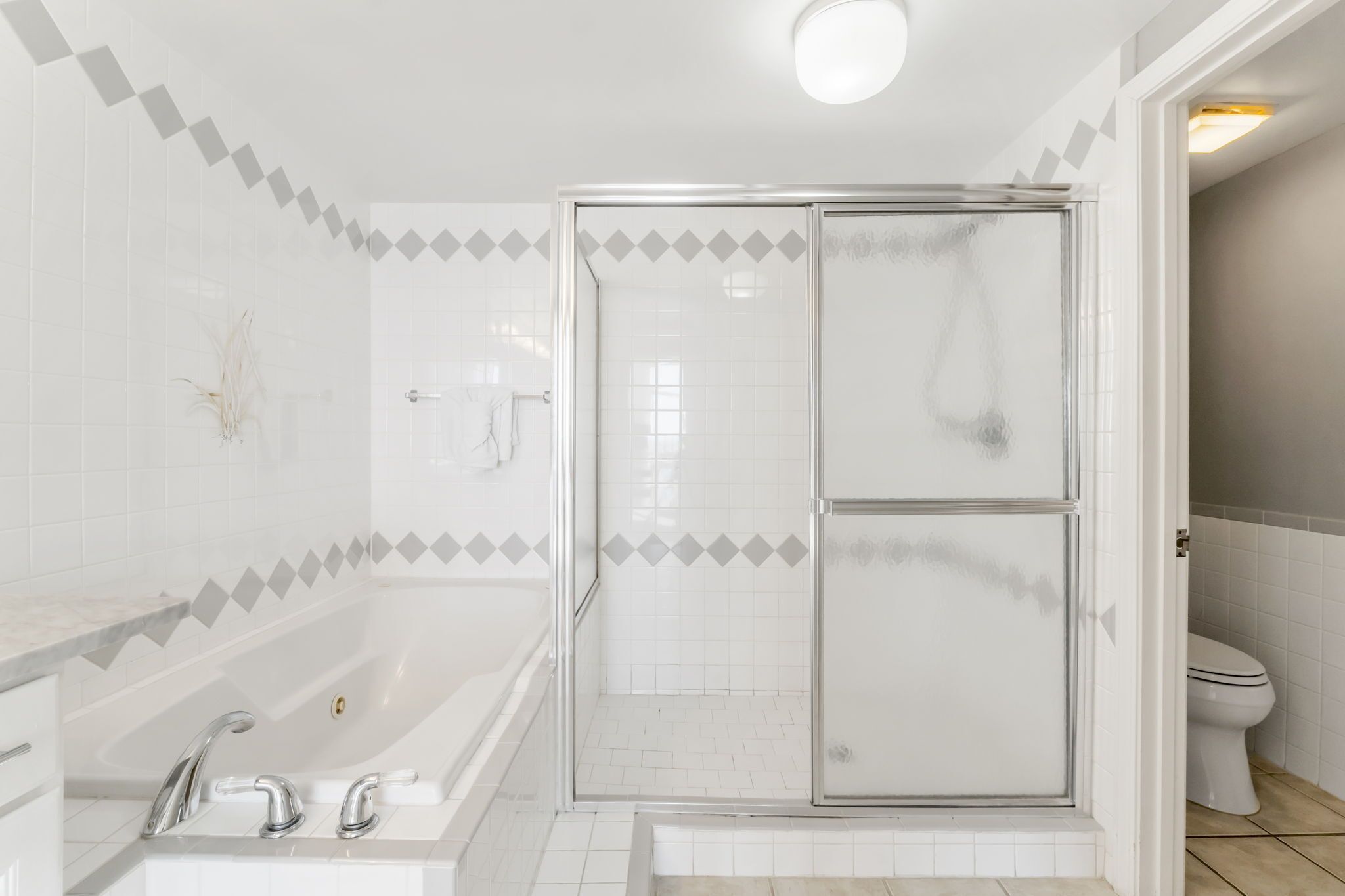A modern bathroom with a glass-enclosed shower, a standalone bathtub, and a toilet.