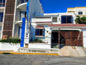 Stylish building with a modern facade, featuring a blue accent and a red-tiled roof.