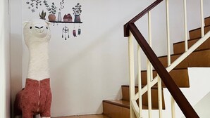 A staircase with a white railing and a wall with a decorative plant shelf. - Experience the Essence of Friendship: in the Heart of the Old Town (Phuket)