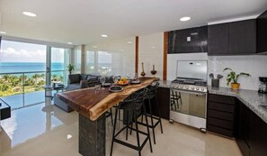 Enjoy a serene dining experience with a view of the ocean from the balcony, where the kitchen's central island and ample counter space make cooking and entertaining a breeze.