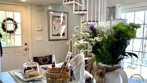 Una encimera de cocina con un pastel, una copa de champán y un jarrón con flores.