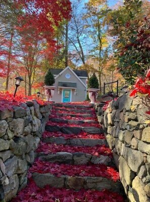 A stone staircase leading to a house surrounded by autumn foliage. - The Cottage by the Lake: Hudson Valley Indulgence/1 hr. from NYC/welcome pets!. (Brewster)