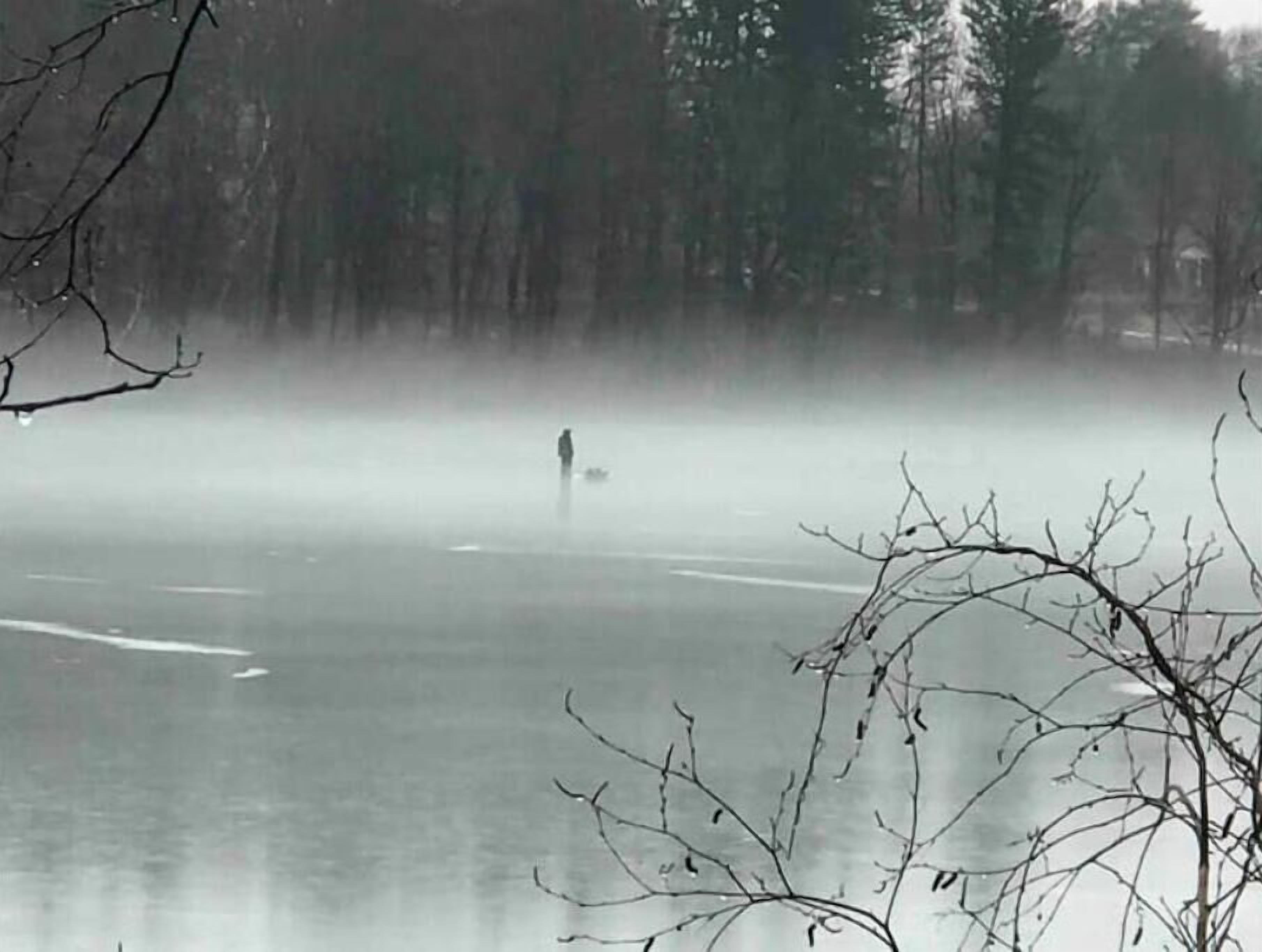 Henkilö kävelee sumuisen järven jäällä, ja järveä ympäröivät puut.
