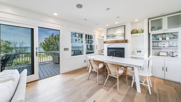 A modern kitchen with a large island, white cabinetry, and a view to the outdoors.
