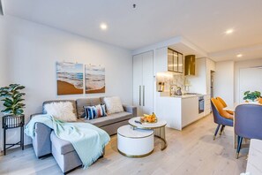 A modern living room with a sofa, coffee table, and artwork on the wall.