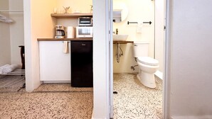 A compact kitchen with a coffee maker, a small refrigerator, and a sink. - Boho Chic 2 bedroom - Miramar -1A (San Juan)