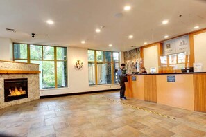Welcome to our hotel, where a large window lets in plenty of natural light, and a cozy fire crackles in the background.