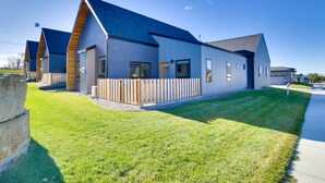 A modern building with a sloped roof, large windows, and a fenced outdoor area. - Pet-Friendly Bozeman Home ~ 7 Mi to Downtown! (Bozeman)