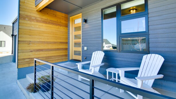 A wooden exterior with a blue door and windows, two white Adirondack chairs, and a small table on a balcony. - Pet-Friendly Bozeman Home ~ 7 Mi to Downtown! (Bozeman)