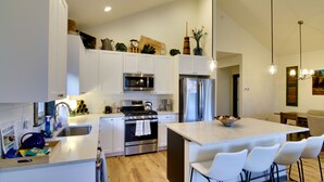 A modern kitchen with white cabinets, stainless steel appliances, and a central island with bar seating. - Pet-Friendly Bozeman Home ~ 7 Mi to Downtown! (Bozeman)