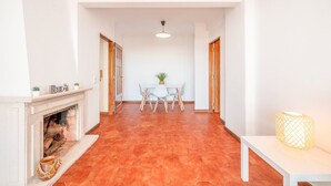 A hallway with a fireplace, a dining table with chairs, and a lamp. - GuestReady - Charming stay with a terrace (Cascais)
