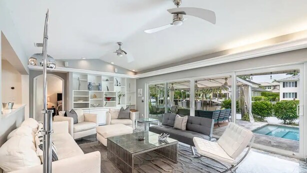 A spacious living area with a pool, modern furniture, and a large glass door leading to an outdoor patio. - Casa Flamingo Intracoastal Heated Pool (Fort Lauderdale)