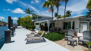 A waterfront property with a dock, lounge chairs, and a pool area. - Casa Flamingo Intracoastal Heated Pool (Fort Lauderdale)