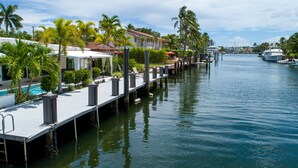 A waterfront property with a dock, pool, and palm trees. - Casa Flamingo Intracoastal Heated Pool (Fort Lauderdale)