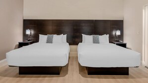 A double room with two beds, a dark headboard, bedside lamps, and a clock on the nightstand. - The Grant Street Inn Dunedin Downtown Historic District, an Ascend Collection Hotel (Dunedin)
