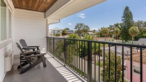 A balcony with a wooden ceiling, a black metal railing, and a view of a residential area with houses and trees. - The Grant Street Inn Dunedin Downtown Historic District, an Ascend Collection Hotel (Dunedin)