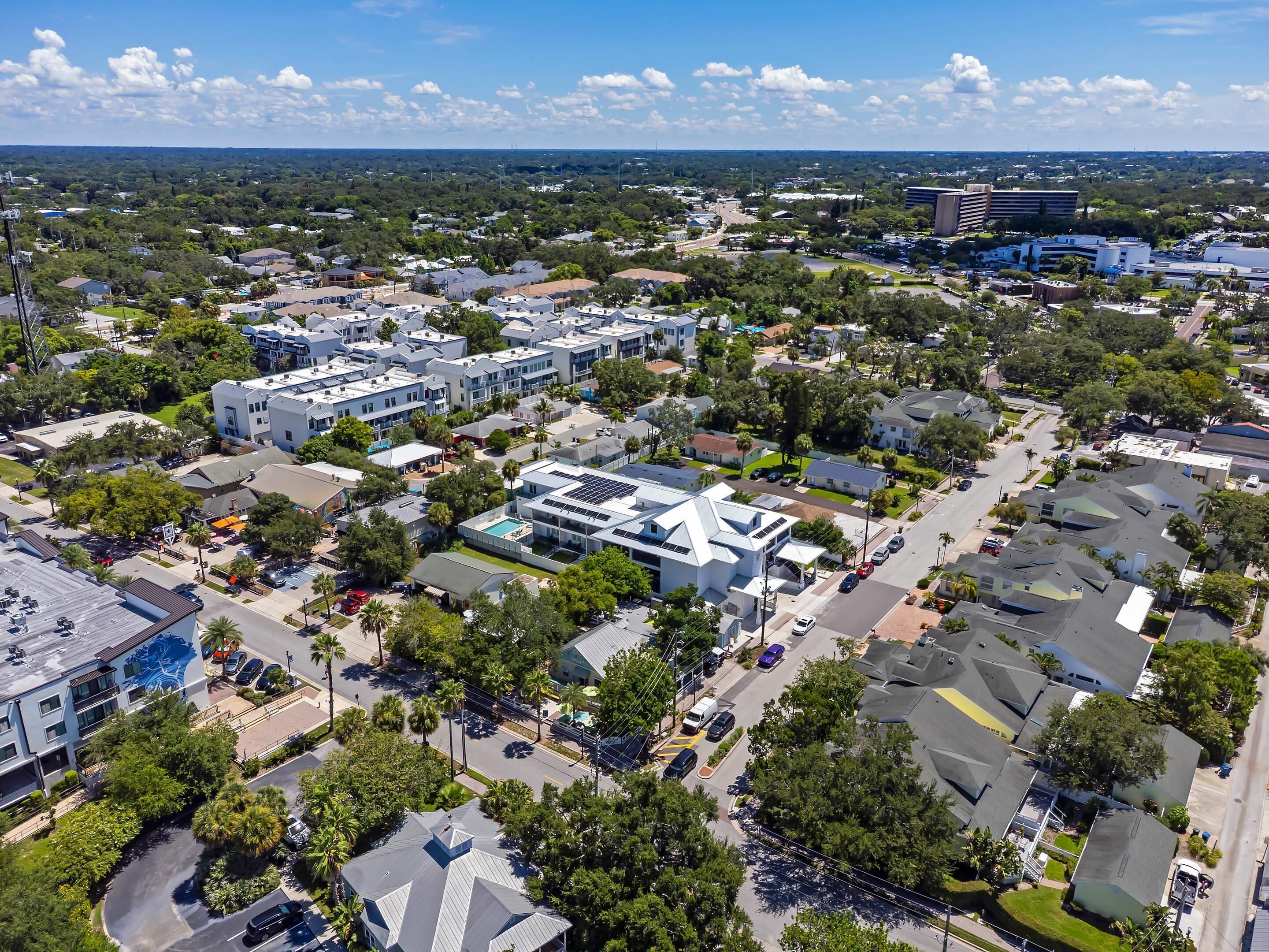 An aerial view of a residential area with multiple buildings, roads, and greenery.