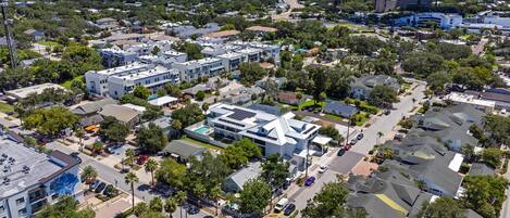 An aerial view of a residential area with multiple buildings, roads, and greenery.