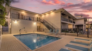 A two-story building with a swimming pool, outdoor seating, and a staircase. - The Grant Street Inn Dunedin Downtown Historic District, an Ascend Collection Hotel (Dunedin)