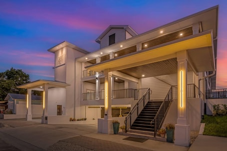 A multi-story hotel with a covered entrance, outdoor seating area, and a staircase leading to the upper levels.. The Grant Street Inn Dunedin Downtown Historic District, an Ascend Collection Hotel