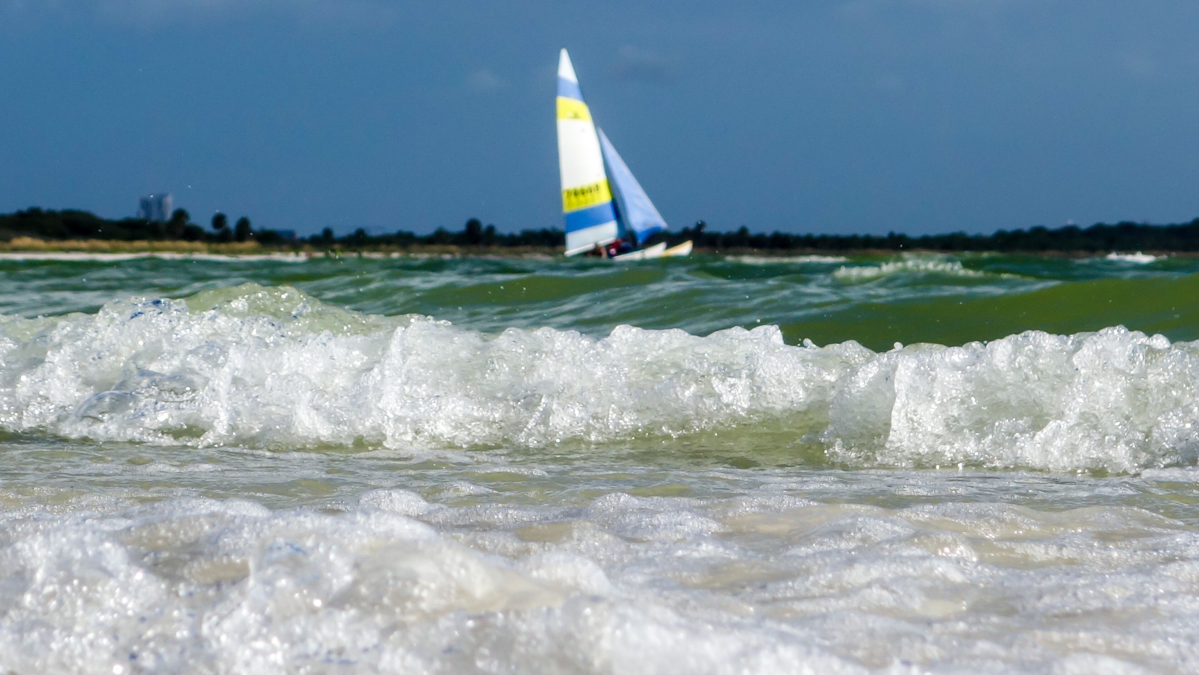 Un velero en el agua, con olas en primer plano.