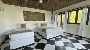 Una habitación con dos camas, piso a cuadros, pared de piedra y ventilador de techo.