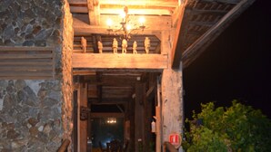 Una escalera de piedra que lleva a una puerta de madera con un pequeño porche.