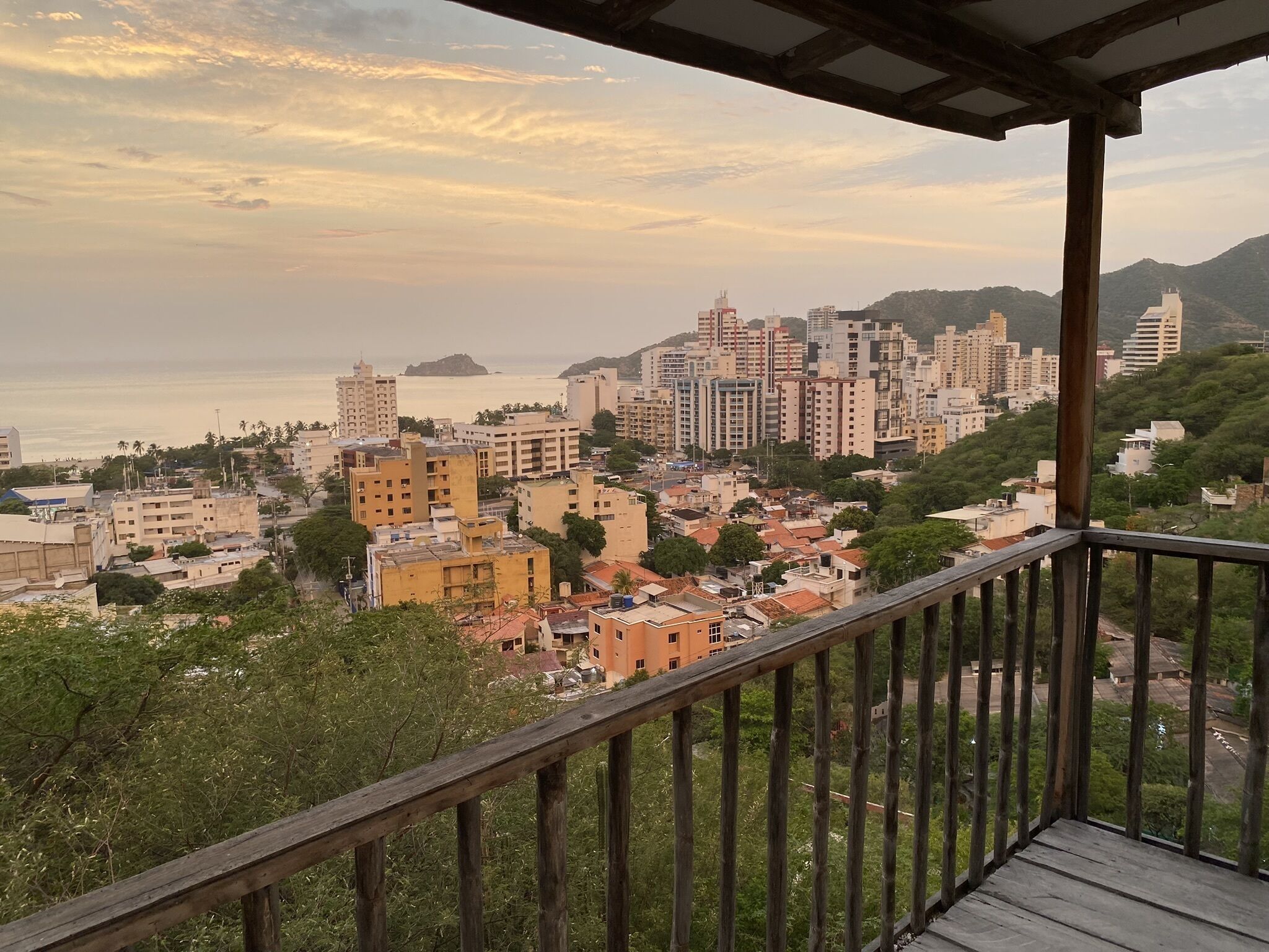 Un balcon offrant une vue sur le paysage urbain de la côte au coucher du soleil.