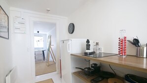 A compact kitchen with a refrigerator, coffee maker, and a fruit basket. - LBS 3 · Copenhagen Hotel Apartments (København)