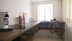 A kitchen with a wooden countertop, a coffee maker, a cutting board, and a window with natural light. - LBS 3 · Copenhagen Hotel Apartments (København)