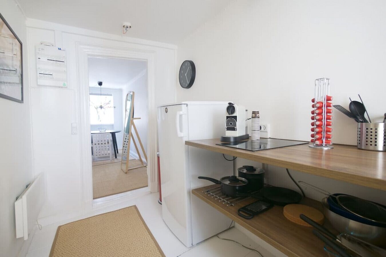 Una cocina compacta con un refrigerador, una cafetera y un juego de cuchillos en la encimera.