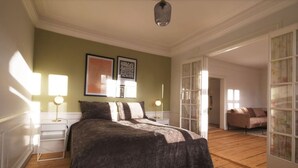 A bedroom with a large bed, two bedside tables with lamps, a framed artwork above the bed, and a wooden floor. - New Harbour / Carolina's Apartments / 2 BR (København)