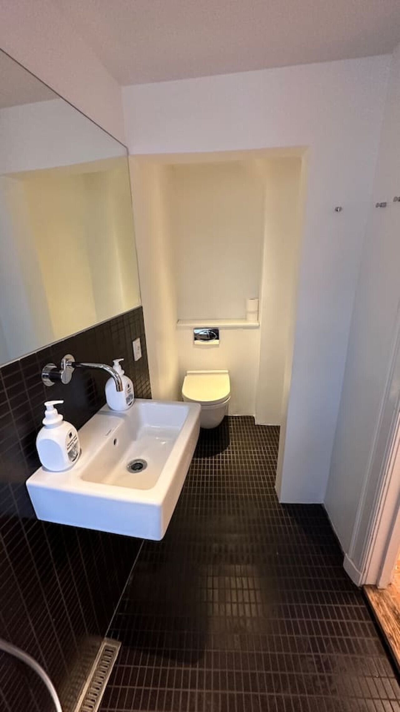 Un bagno piccolo con un lavandino bianco, un water e uno specchio.