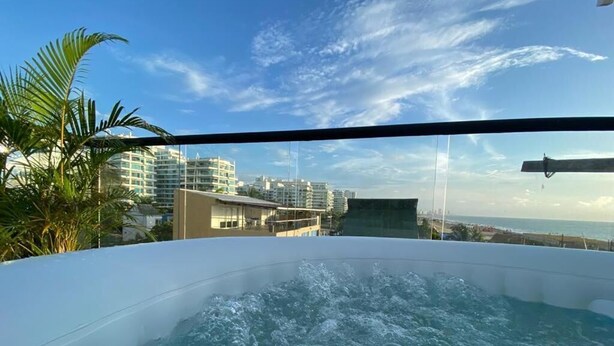 A hot tub with a view of a cityscape and palm trees. - Casa Colors (Cartagena)