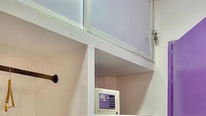 A room with a purple door, white walls, and a white cabinet with a small electronic device on one of the shelves. - Casa Colors (Cartagena)