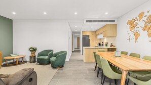 Un apartament modern amb zona de menjador, cuina i un mapa del món a la paret.