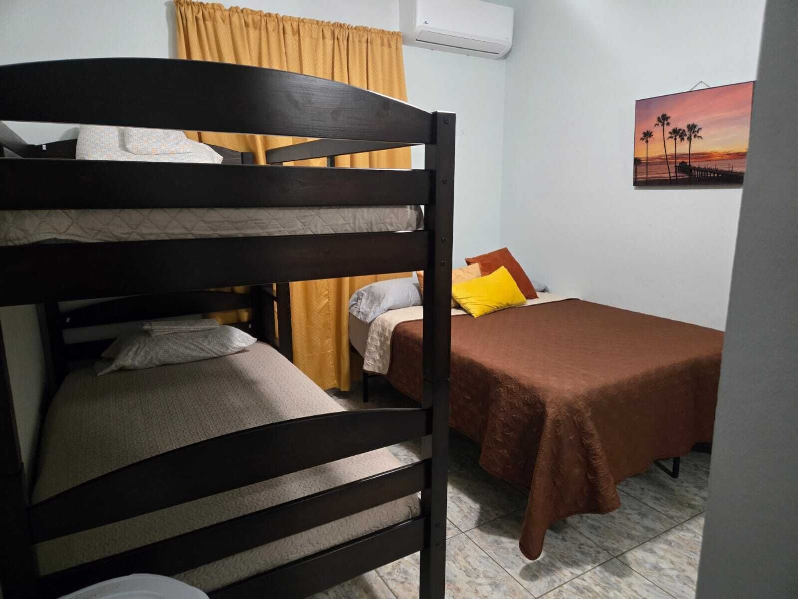 A bunk bed room with a single bed and a desk area.